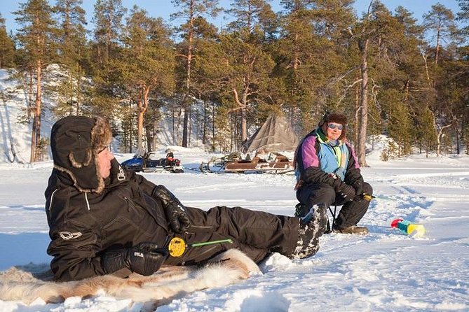 From Saariselkä: Ice Fishing Tour to Lake Inari, reindeers &lunch - Making a fishing hole in the ice